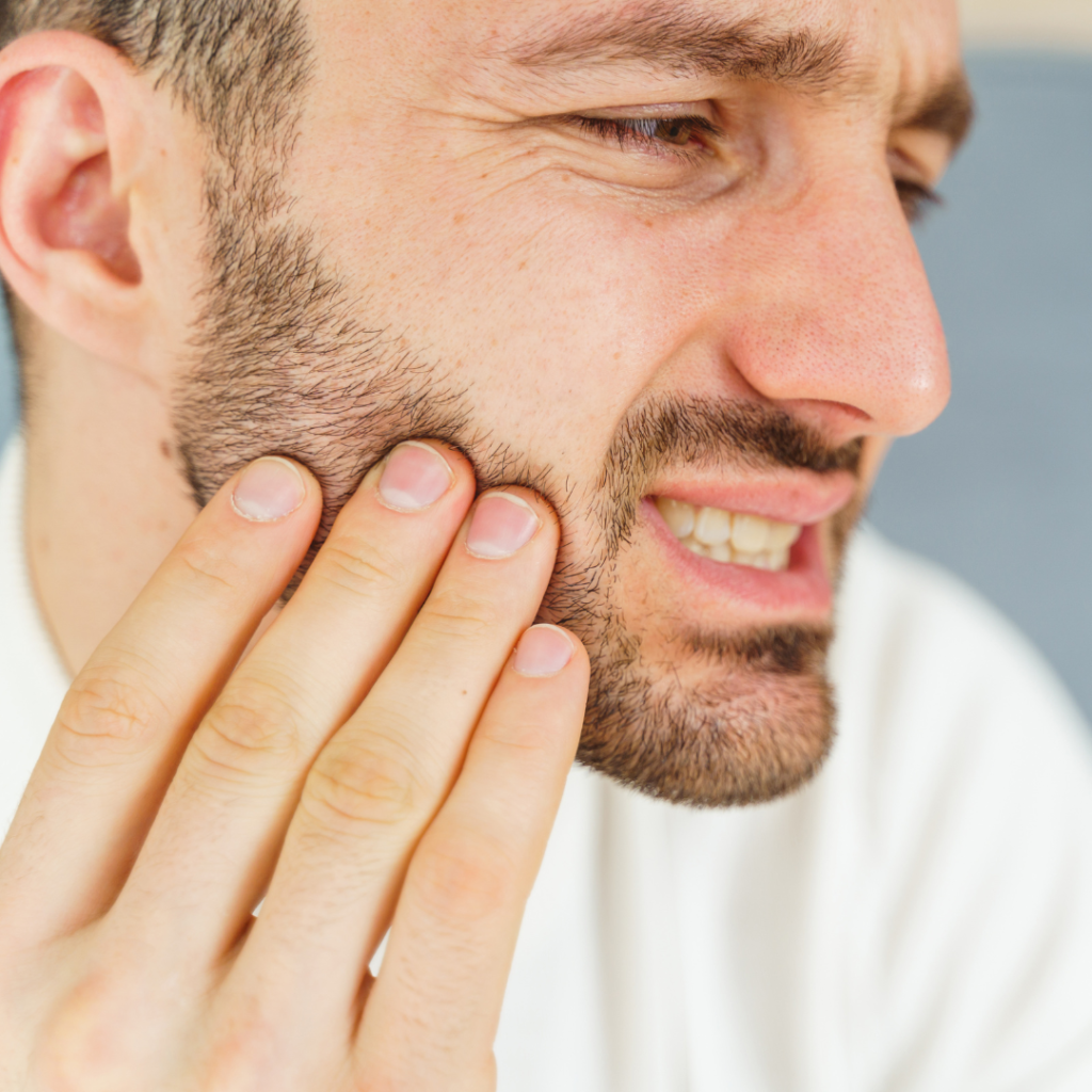 Tooth extractions in Leicester at Smile Perfections dentist Leicester, showing a man holding his cheek in pain, indicating the need for dental removal treatment.