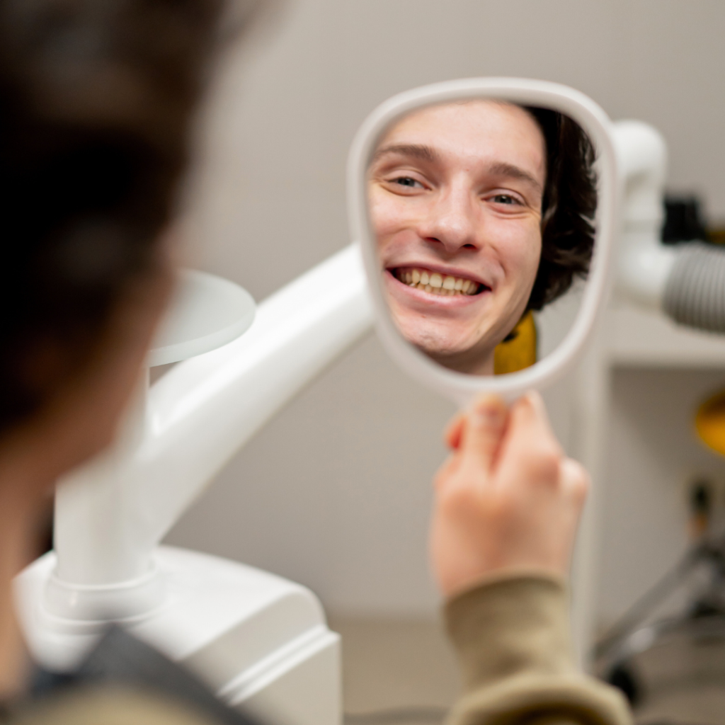 What to expect during a dental hygiene appointment in Leicester at Smile Perfections dentist Leicester, showing a man holding a mirror and smiling after his cleaning.