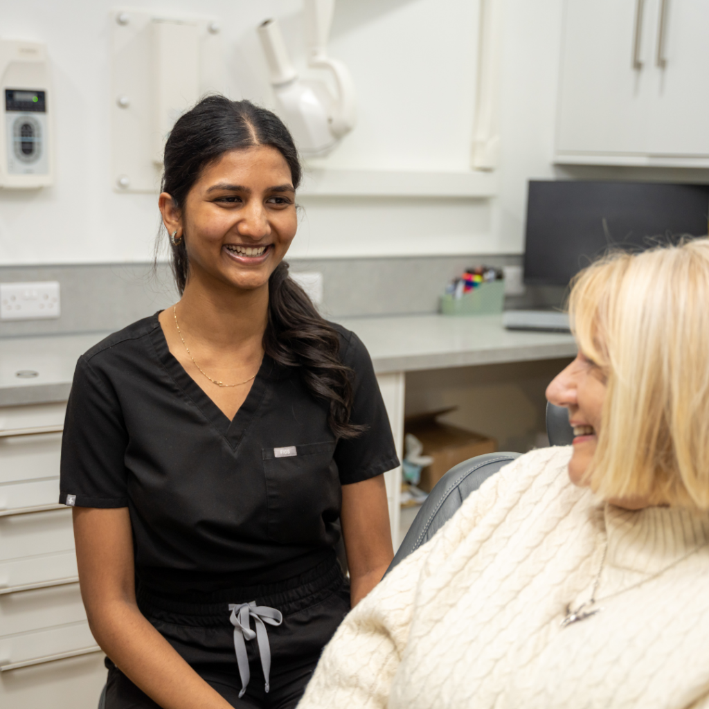 Jeromini, the hygienist at Smile Perfections dentist Leicester, smiling warmly at a patient, creating a friendly and comforting dental care environment.