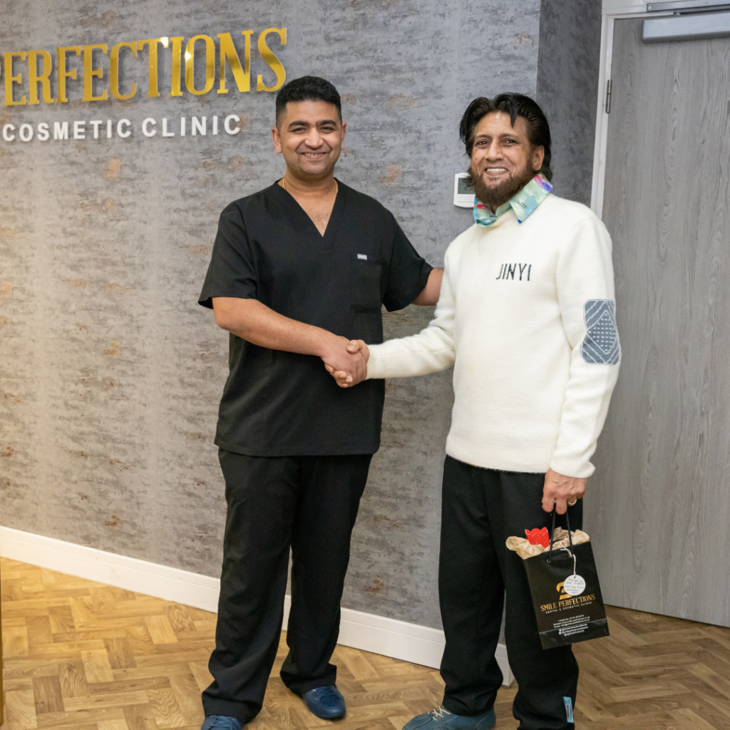 Dr Juttes shaking hands and smiling with a patient at Smile Perfections dentist Leicester, symbolizing trust and satisfaction after dental treatment.