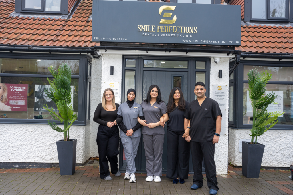 Smile Perfections dentist Leicester team photo at the practice entrance, featuring the welcoming and experienced dental professionals.