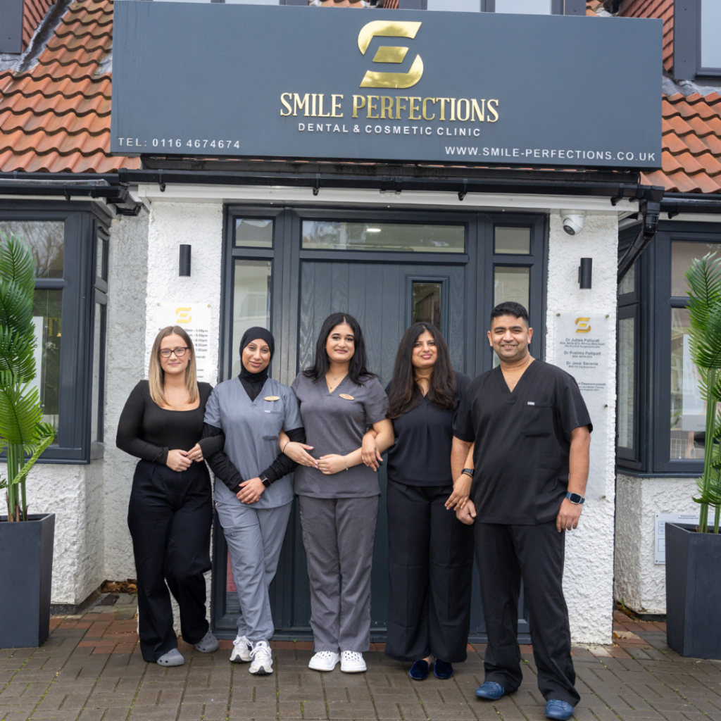 Smile Perfections dentist Leicester staff group photo at the entrance of the dental practice in Leicester, showcasing the friendly and professional team.