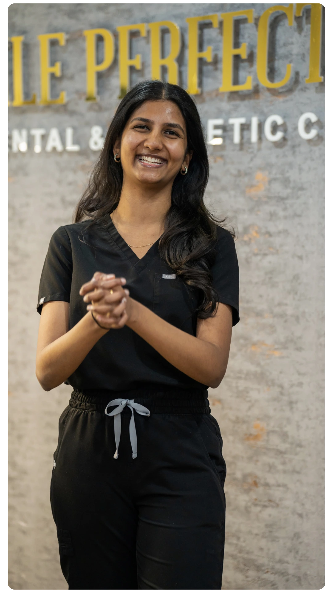Hygienist at Smile Perfections in Leicester smiling at the reception desk, creating a friendly and welcoming atmosphere for patients.
