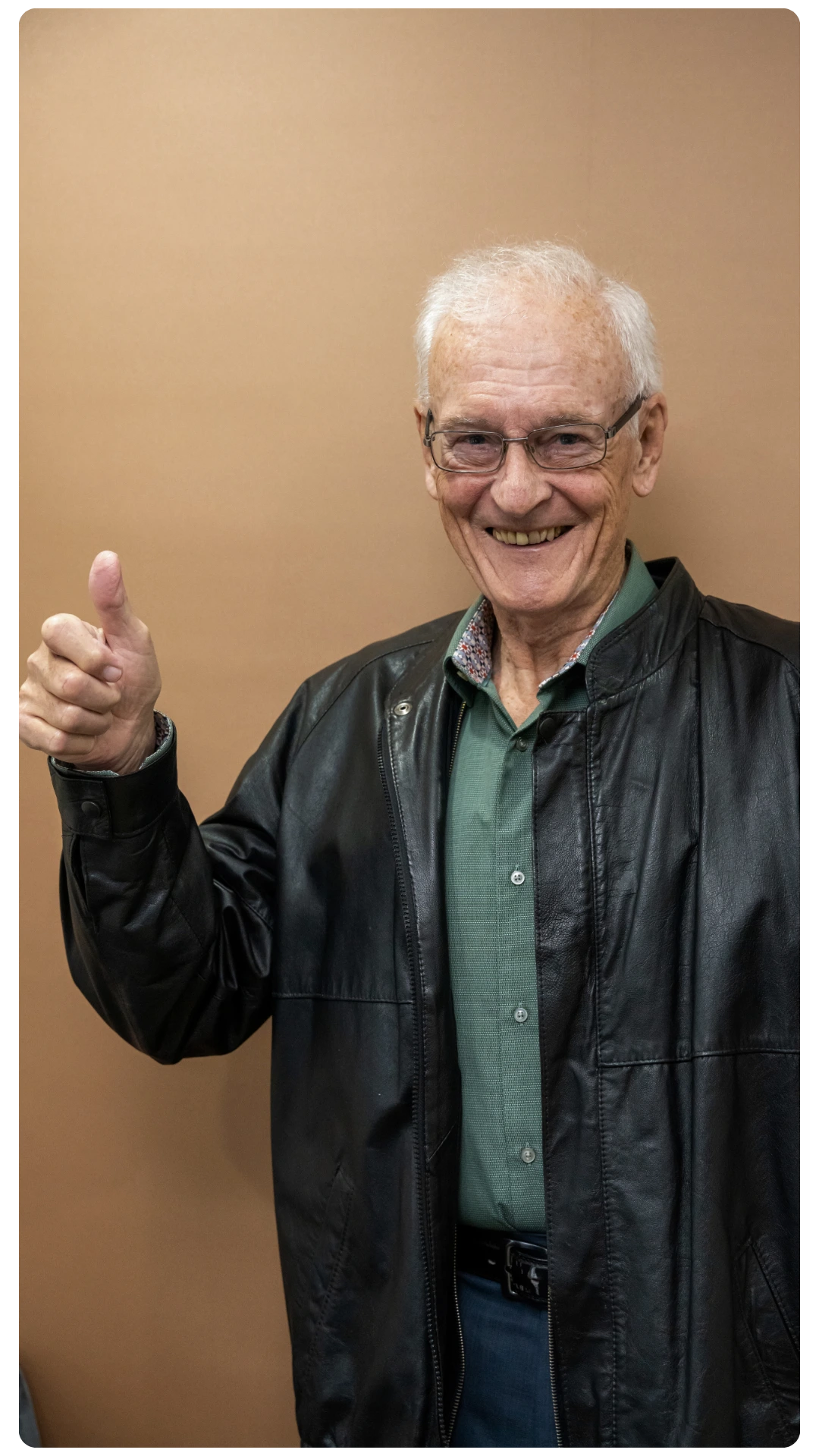 Older male patient smiling and giving a thumbs up at Smile Perfections in Leicester, expressing satisfaction and confidence after dental treatment.