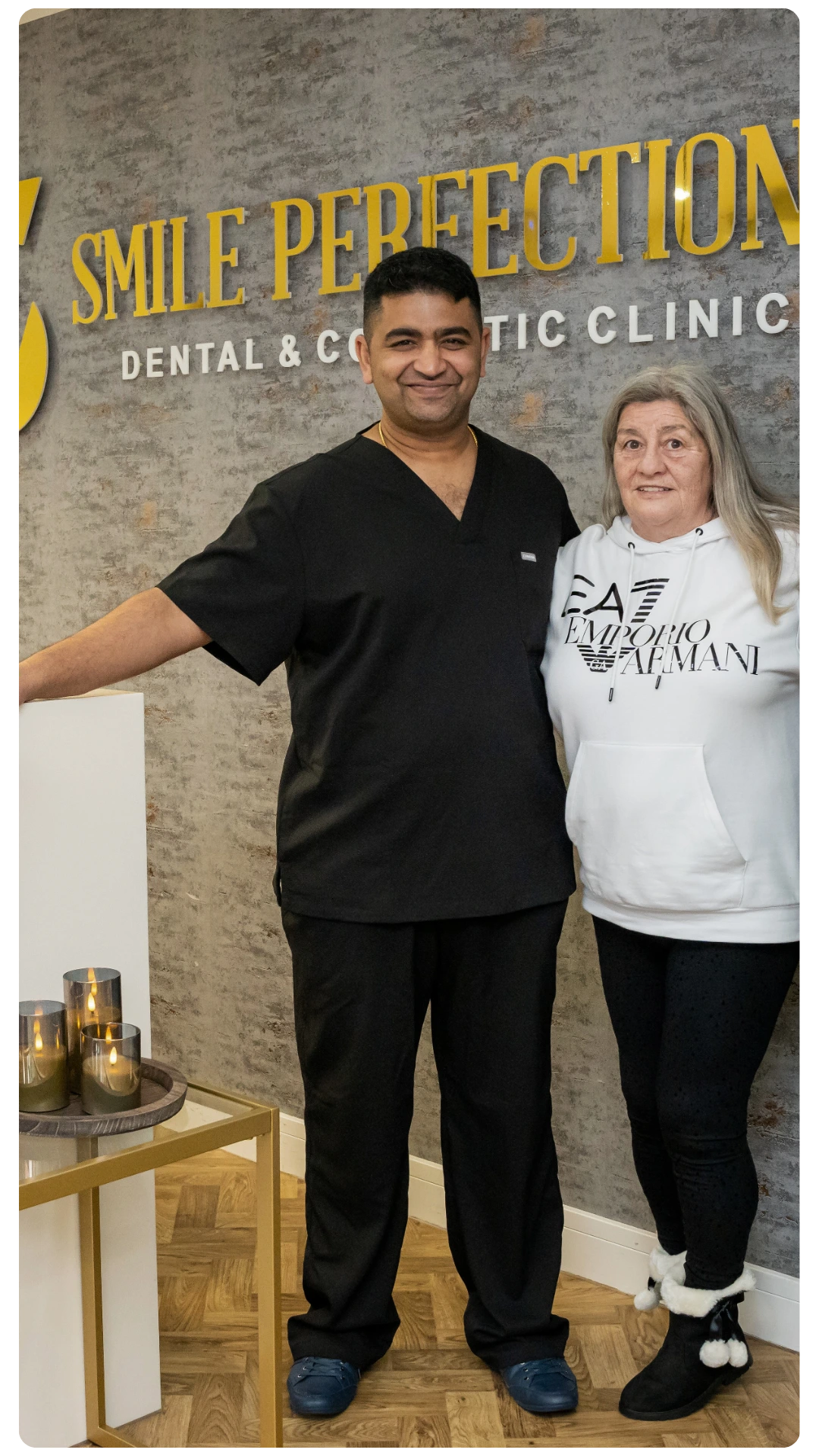 Dr Juttes Pallipatt at Smile Perfections in Leicester smiling with a female patient at the reception, reflecting a warm and welcoming dental experience.