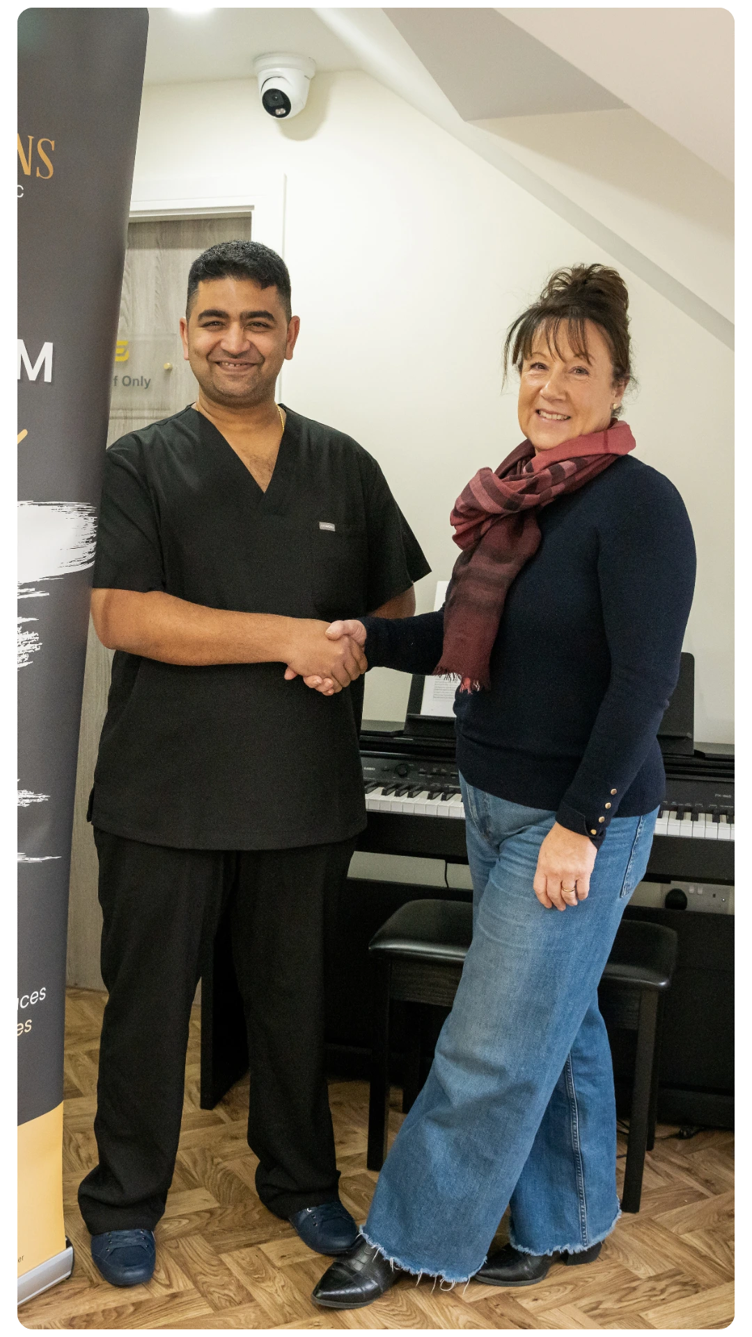 Dr Juttes Pallipatt at Smile Perfections in Leicester shaking hands with a female patient, both smiling after a successful and positive dental experience.